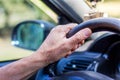Man`s hand on steering wheel of a car. Driving on the road_ Royalty Free Stock Photo