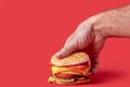 A man`s hand takes a large juicy Burger. Burger with cheese, vegetables, cutlets Royalty Free Stock Photo