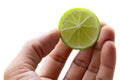 A man`s hand takes a slice of organic fresh green lemon Royalty Free Stock Photo