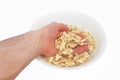 A man`s hand takes a white seed from a plate isolated on a white background.