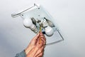 Man`s hand with a tool tightens the lamp cord