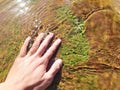 a man's hand touches a rock with hot water flowing. Royalty Free Stock Photo