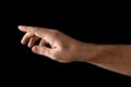 Man`s hand touching or pointing to something isolated on black background. Close up. High resolution Royalty Free Stock Photo