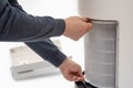 A man`s hand turning an air purifier`s filter into a new one.