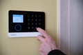 Man`s hand unlocking and disarming the home security alarm