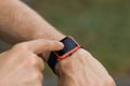 Man`s hand that uses a smart watch to view incoming messages and calls to a mobile phone that lies in the pocket