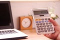 Man`s hand using calculator and laptop on the desk. Concept of calculation and annual tax refund