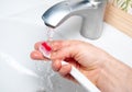 A man`s hand washes a toothbrush under the tap Royalty Free Stock Photo