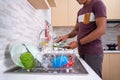 Man`s hand washing plate in the kitchen sink Royalty Free Stock Photo