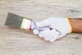 Man`s hand wearing white glove holding old grunge paintbrush on Royalty Free Stock Photo