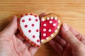 Man`s hand and woman`s hand holding two half heart shaped cookies attach Royalty Free Stock Photo