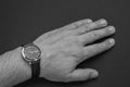 A man`s hand with a wrist watch with hands on a black background Royalty Free Stock Photo