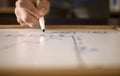 Man`s hand writing formulas on the blackboard