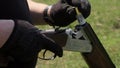 A man`s hands charge a double-barreled rifle with bulet and cartridges