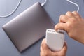 Man`s hands charge laptop with power bank by USB cable. Royalty Free Stock Photo