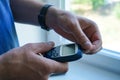 Man`s hands checking blood sugar with glucometer. Male hands close-up