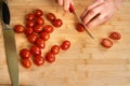 Man`s hands cutting fresh tomatos in the kitchen, preparing a meal for lunch. Topdown view. Royalty Free Stock Photo