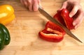 Man`s hands cutting paprika in the kitchen, preparing a meal for lunch. High angle view. Royalty Free Stock Photo