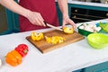 Close up of hands cutting yellow paprika with white knife. Closeup of handsome cook cut yellow paprika.