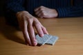 Man`s hands in darkness put a part of playing cards, business strategic competition concept Royalty Free Stock Photo