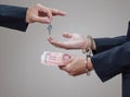 Man's hands in handcuffs and money in his palms Royalty Free Stock Photo