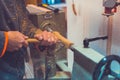 Man`s hands hold chisel near lathe, man working at small wood lathe, an artisan carves a piece of wood using a manual lathe Royalty Free Stock Photo