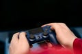 A man`s hands hold a console controller in the foreground of the photo Royalty Free Stock Photo