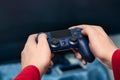 The man`s hands hold the console controller in the foreground. Playing video games at home. Hobbies in modern times Royalty Free Stock Photo