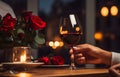 Man\'s hands holding hands of girl on restaurant table day light with two red wine glasses and red roses flower Royalty Free Stock Photo