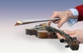 Man's hands holding old violin and a bow Royalty Free Stock Photo