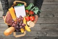 Man`s hands holding paper bag of groceries with blank notebook Royalty Free Stock Photo