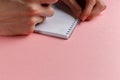 Man's hands holding pencil and spiral notepad as mockup for your design. Pink background Royalty Free Stock Photo