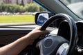 Man`s hands holding steering wheel while driving car on city road Royalty Free Stock Photo