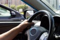 Man`s hands holding steering wheel while driving car on city road Royalty Free Stock Photo