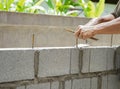 Man`s hands  of industrial bricklayer with  steel bar installing brick blocks on construction site Royalty Free Stock Photo