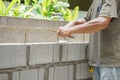 Man`s hands  of industrial bricklayer with  steel bar installing brick blocks on construction site Royalty Free Stock Photo