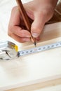 Man's hands measuring board's length