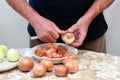 Man's hands peeling freh raw onion with kitchen knife on the kitchen table