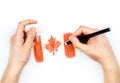 Man's hands with pencil draws flag of Canada on white