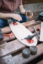 Man`s hands placing wheels to wooden skateboard