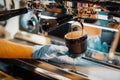 Man's hands prepares coffee, fresh espresso pours into porcelain cup. Making coffee in coffee machine. Royalty Free Stock Photo