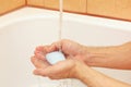Man`s hands with soap under running water in bathroom Royalty Free Stock Photo