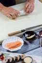 Man's hands touch sushi roll.