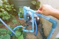 Man's hands turning the water valve on the water pump motor