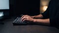 Man's Hands Typing on Keyboard in Dark Office at Night Royalty Free Stock Photo