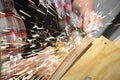 Man`s hands using an angle grinder with sparks flying.