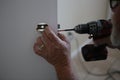 Man`s hands using drill to repair door knob