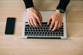 Man`s hands using laptop with blank screen on desk in home interior. Mockup image white screen Royalty Free Stock Photo