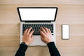 Man`s hands using laptop with blank screen on desk in home interior. Mockup image white screen