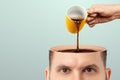 The man`s head is open and coffee is poured into it from a cup. Creative background, coffee lover, brain drug, caffeine